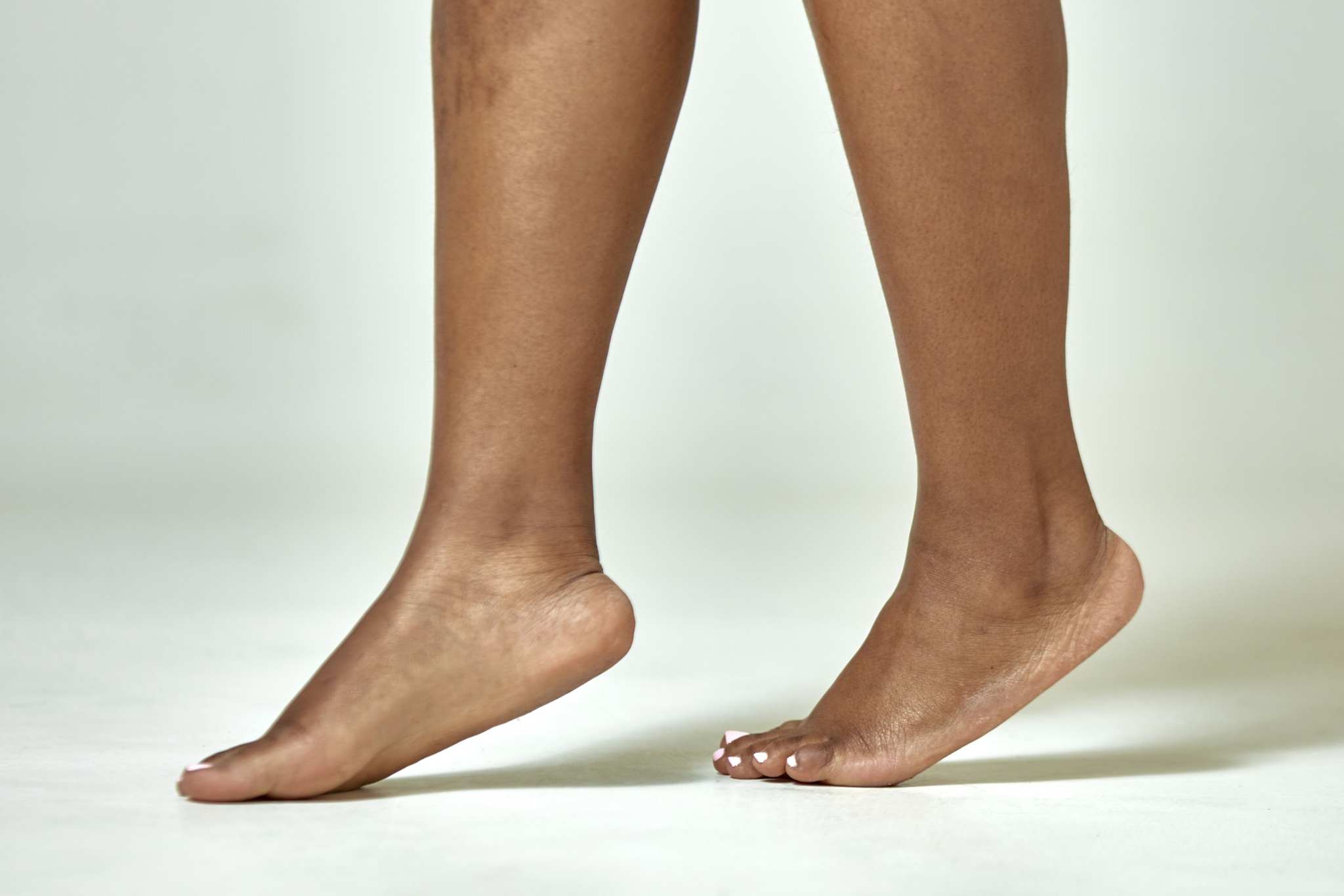 African american female feet with fat ankles. Black woman legs step on tiptoe, walking. Podiatry, body positive concept